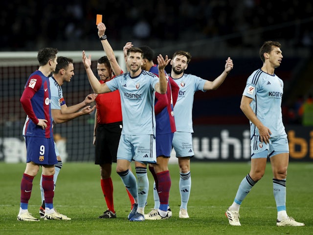 Osasuna's Unai Garcia is shown a red card by referee Jorge Figueroa Vazquez as teammates react on January 31, 2024