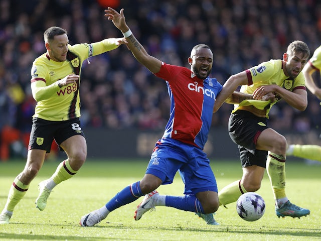 Crystal Palace's Jordan Ayew in action with Burnley's Josh Brownhill and Charlie Taylor on February 24, 2024