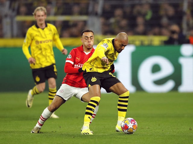  Donyell Malen dari Borussia Dortmund beraksi bersama Sergino Dest dari PSV Eindhoven pada 13 Maret 2024 © Reuters