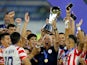 Paraguay Under-23s coach Carlos Jara Saguier and players celebrate winning the tournament with the trophy after qualifying for the Paris Olympics 2024 on February 11, 2024