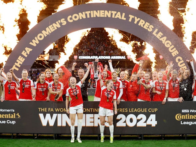 Arsenal's Leah Williamson and Kim Little lift the trophy as they celebrate with teammates after winning the League Cup on March 31, 2024