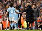 Manchester City's Nathan Ake shakes hands with manager Pep Guardiola as he walks off the pitch after sustaining an injury on March 31, 2024