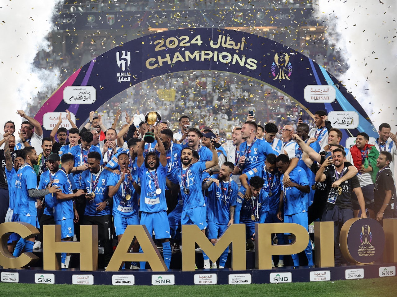 Al Hilal's Salem Al-Dawsari lifts the trophy with teammates after winning the Saudi Super Cup final on April 11, 2024