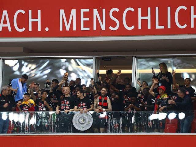 Bayer Leverkusen players celebrate winning the Bundesliga with the trophy on April 14, 2024