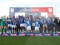 Stockport County's Paddy Madden and Ryan Croasdale lift the trophy as they celebrate with teammates after winning League Two on April 20, 2024