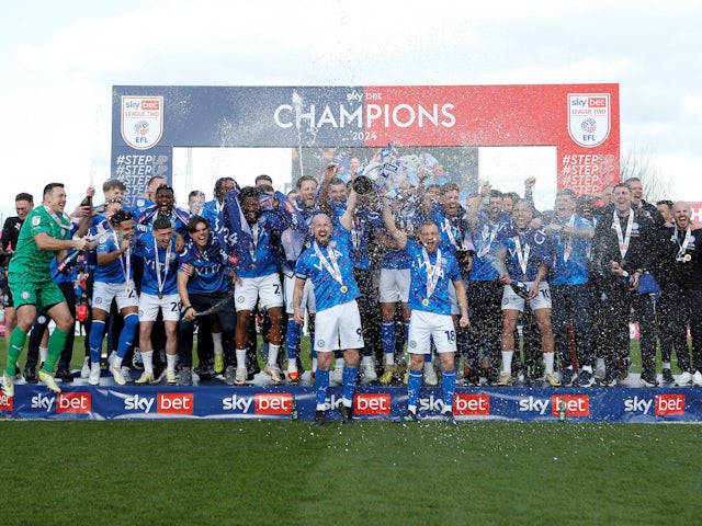 Stockport County's Paddy Madden and Ryan Croasdale lift the trophy as they celebrate with teammates after winning League Two on April 20, 2024