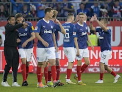 Holstein Kiel's Benedikt Pichler celebrates scoring their first goal with teammates and coach Marcel Rapp on May 11, 2024