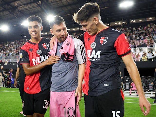 Franco Diaz and Esteban Martinez of Newell's Old Boys shake hands with Lionel Messi