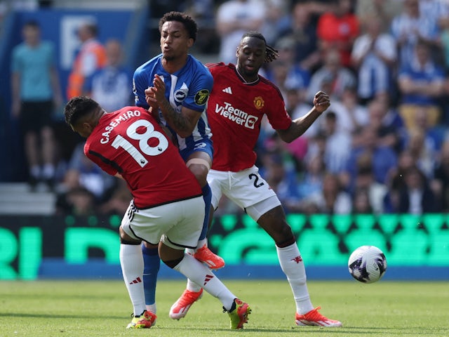 Brighton & Hove Albion's Joao Pedro in action with Manchester United's Aaron Wan-Bissaka and Casemiro on May 19, 2024