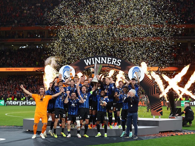 Atalanta's Berat Djimsiti and Ademola Lookman lift the trophy with teammates after winning the Europa League Final on May 22, 2024