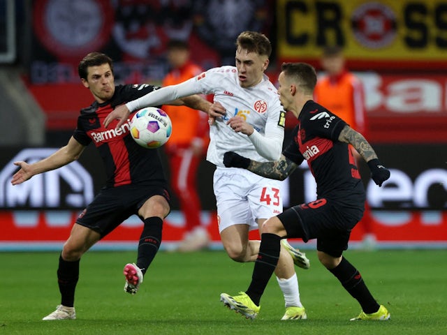 Mainz 05's Brajan Gruda in action with Bayer Leverkusen's Alejandro Grimaldo and Jonas Hofmann on May 25, 2024
