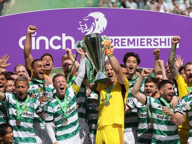 Celtic's Callum McGregor and Joe Hart lift the trophy with teammates after winning the Scottish Premiership on May 18, 2024