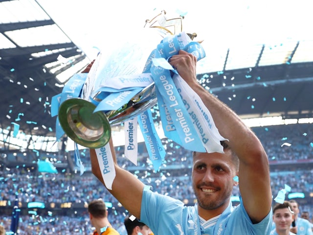 Manchester City's Rodri celebrates with the trophy after winning the Premier League on May 19, 2024