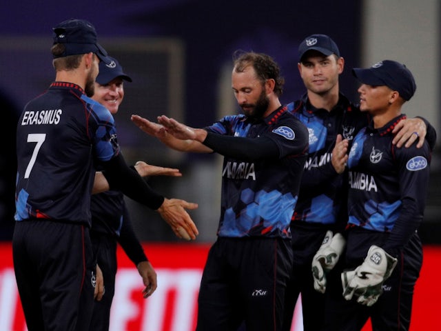 Namibia's Jan Frylinck celebrates with teammates after taking a wicket on November 8, 2021