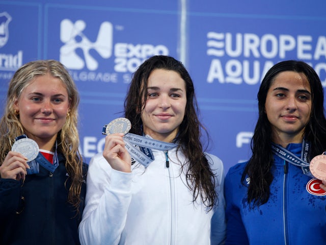 Gold medallist Hungary's Ajna Kesely poses on the podium during the women's 800m freestyle medal ceremony with silver medallist Britain's Fleur Lewis and bronze medallist Turkey's Deniz Ertan on June 18, 2023