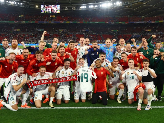 Hungary players celebrate after the match and hold up a shirt with Barnabas Varga's name after he was stretchered off during the match on June 23, 2024
