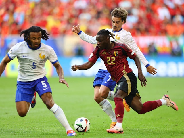 Belgium's Jeremy Doku in action with France's Jules Kounde and Antoine Griezmann on July 1, 2024