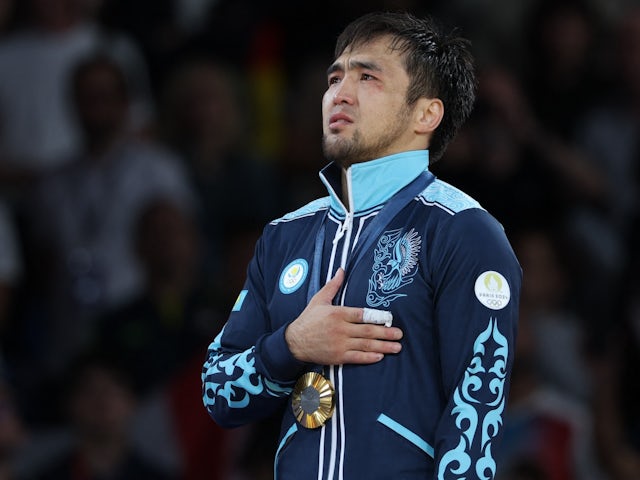 Gold medalist Yeldos Smetov of Kazakhstan pose for pictures on the podium on July 27, 2024