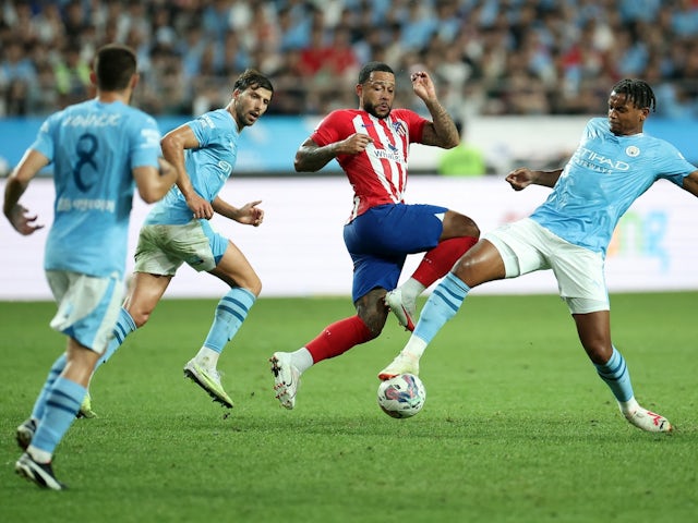 Atletico Madrid's Memphis Depay in action with Manchester City's Manuel Akanji and Ruben Dias on July 30, 2023