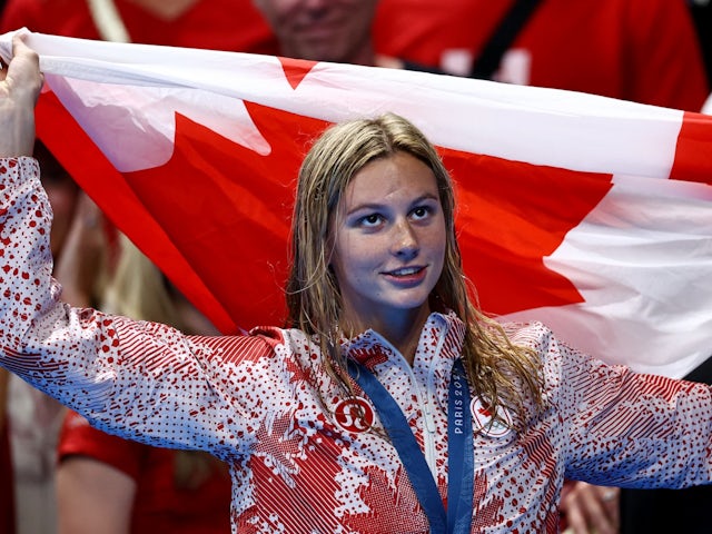 Gold medallist Summer McIntosh of Canada celebrates holding a flag after winning on July 29, 2024