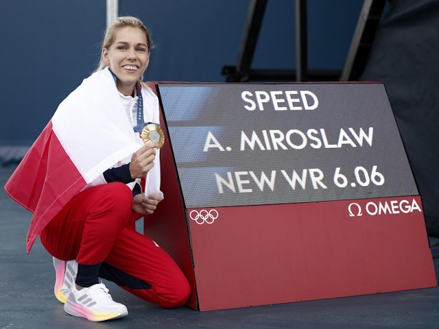 Gold medallist Aleksandra Miroslaw poses with her medal and a board with her new world record on August 7, 2024