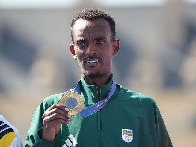 amirat Tola (ETH) celebrates at the medal ceremony after the men's marathon during the Paris 2024 Olympic Summer Games on August 10, 2024