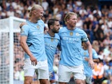 Manchester City's Erling Haaland celebrates with Kevin De Bruyne and Bernardo Silva after scoring their first goal on August 18, 2024