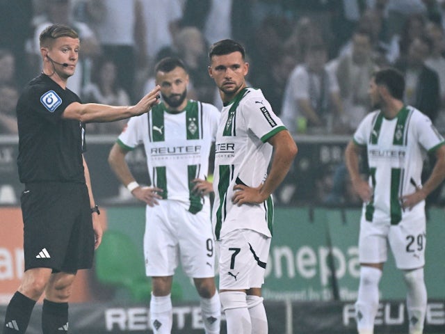 Borussia Monchengladbach players surround the referee in their match against Bayer Leverkusen on August 23, 2024