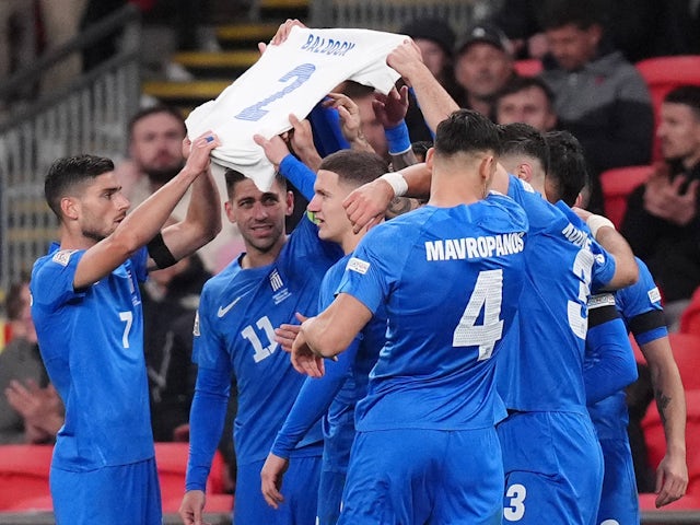 Greece's players hold up a shirt in memory of George Baltak after Vangelis Pavlidis scored the opening goal of the match on October 10, 2024