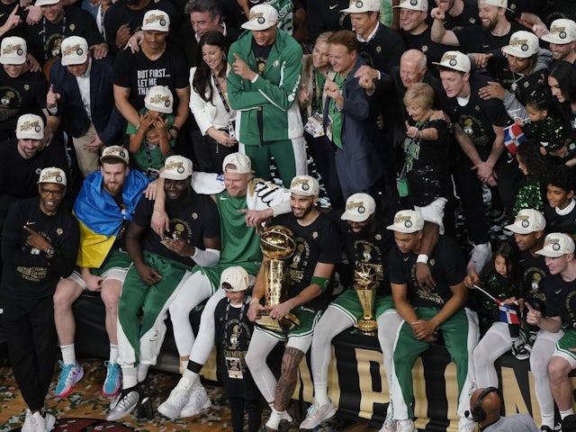 Members of the Boston Celtics pose with trophies after winning the 2023-2024 NBA championship on June 17, 2024