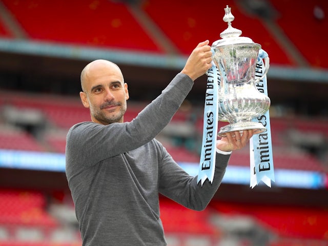 Manchester City manager Pep Guardiola celebrates with the FA Cup trophy on May 18, 2019