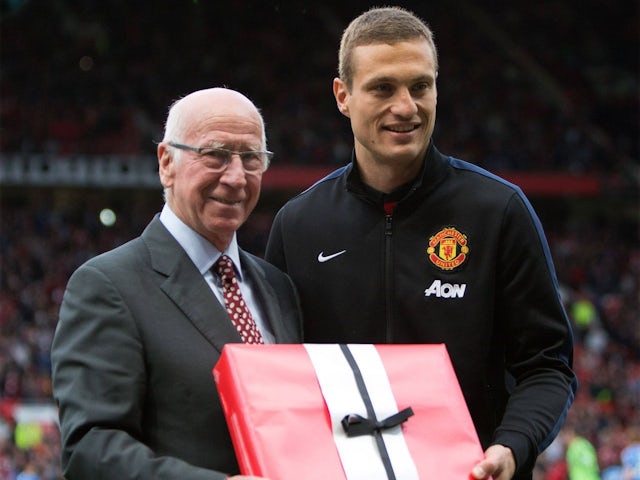 Nemanja Vidic of Manchester United receives a gift from Sir Bobby Charlton, on May 6, 2014